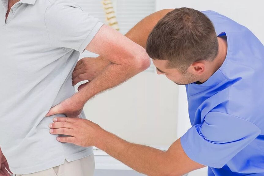 Un paciente con dolor lumbar en un examen de diagnóstico por parte de un médico